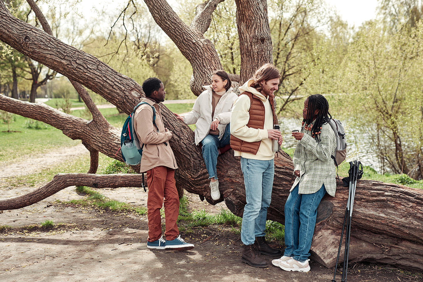 Group of people in outdoor clothing standing by a large tree